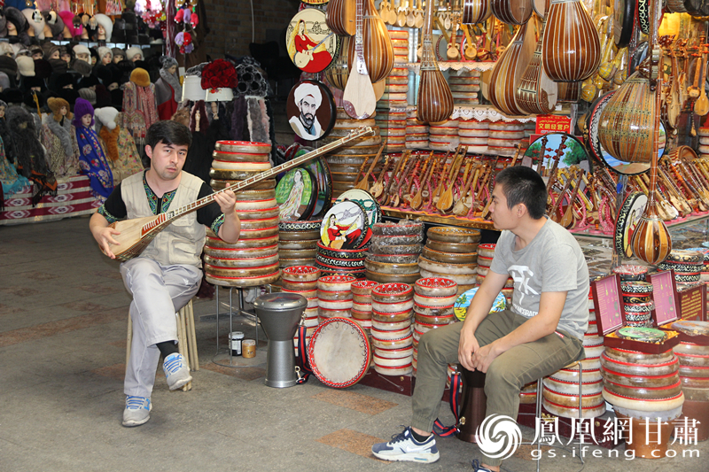 烏魯木齊二道橋巴扎內(nèi)，店主正在向客人展示樂器。楊文遠 攝